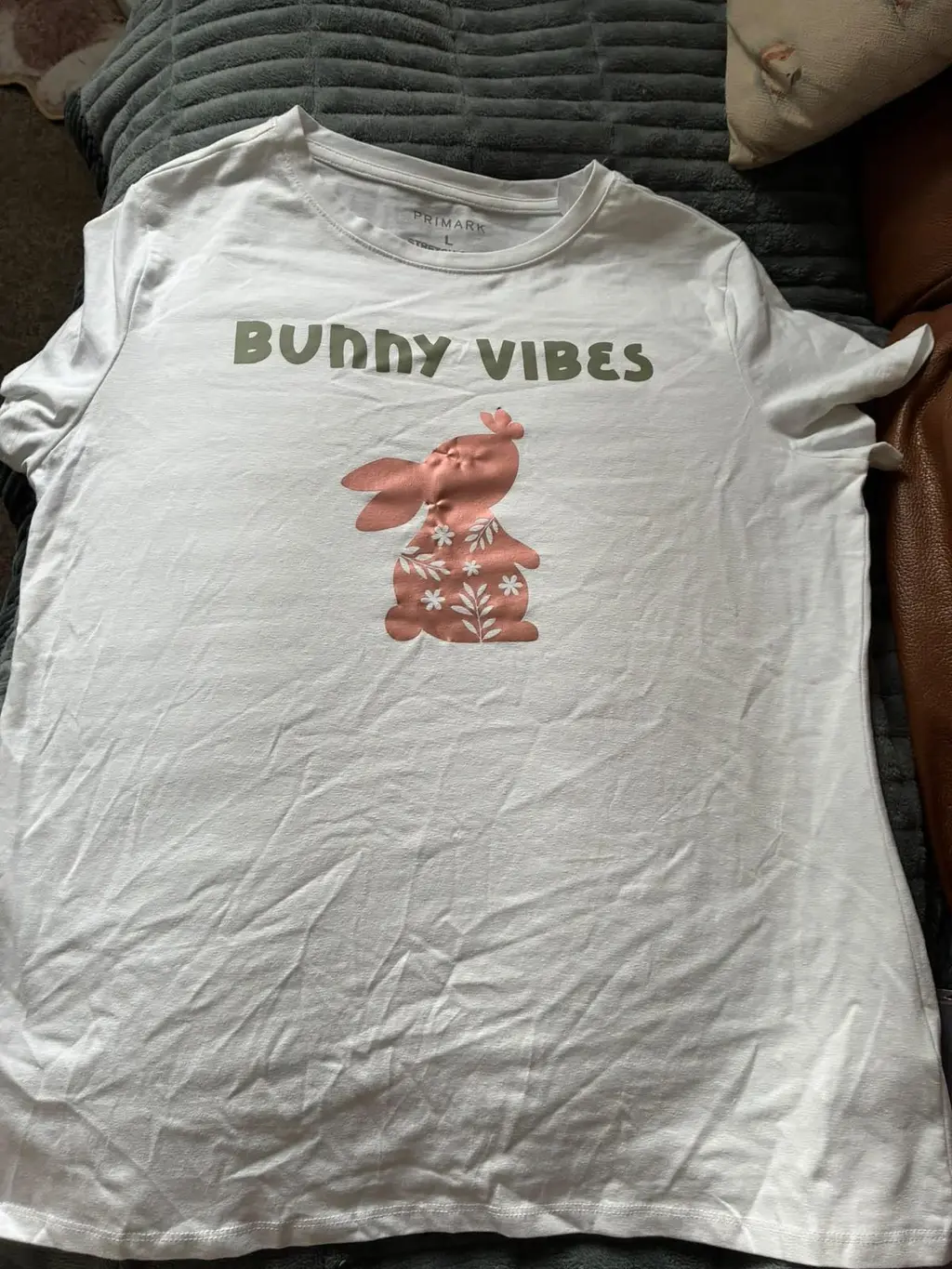 A white t-shirt printed with a pink flowery bunny and the words Bunny Vibes