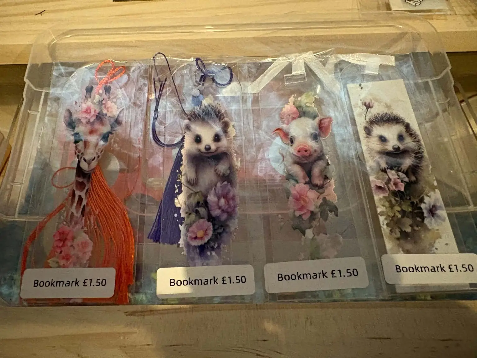 Four animal bookmarks: a giraffe, two hedgehogs and a piglet, each with flowers