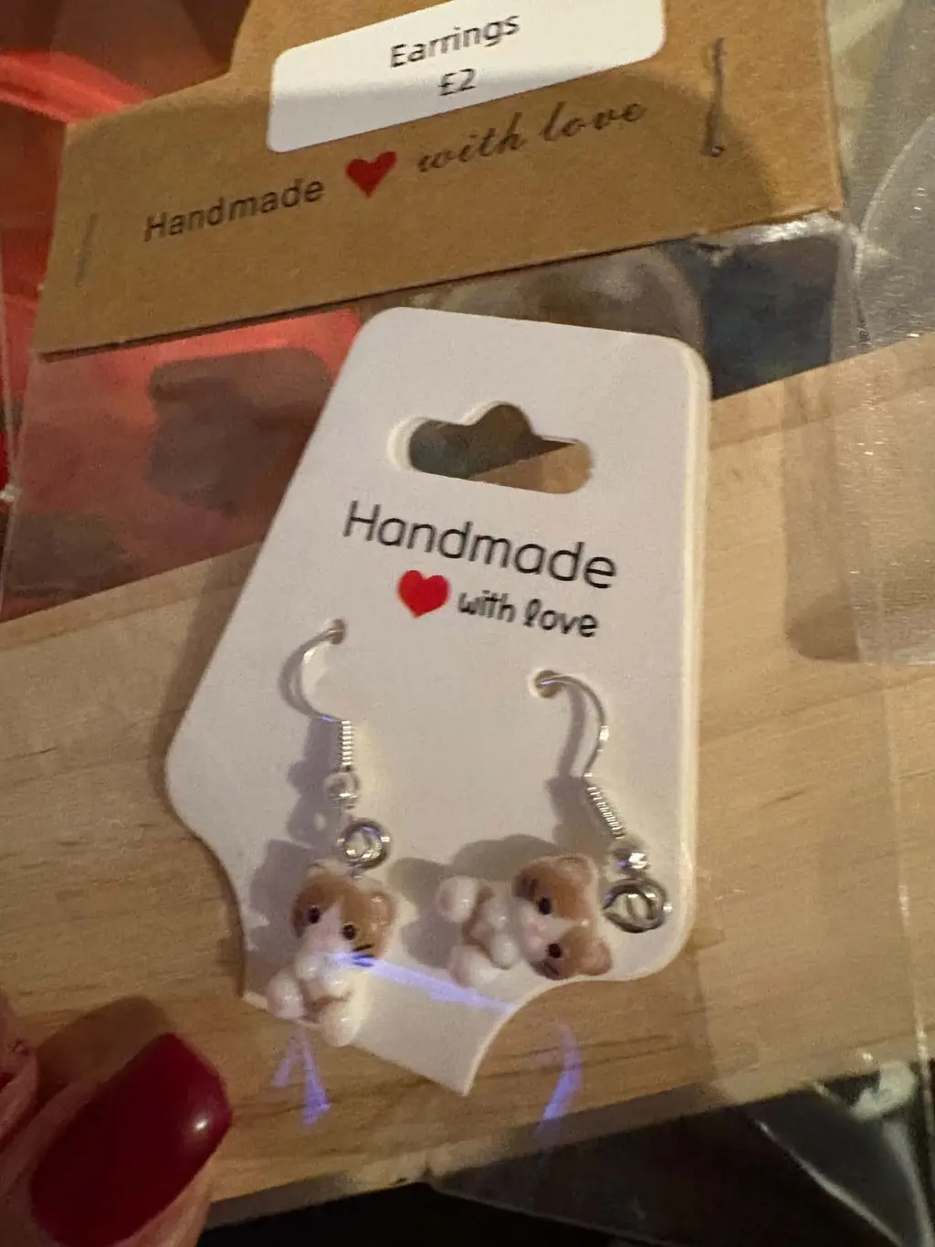 A pair of earrings with brown and white kittens on a Handmade with love card